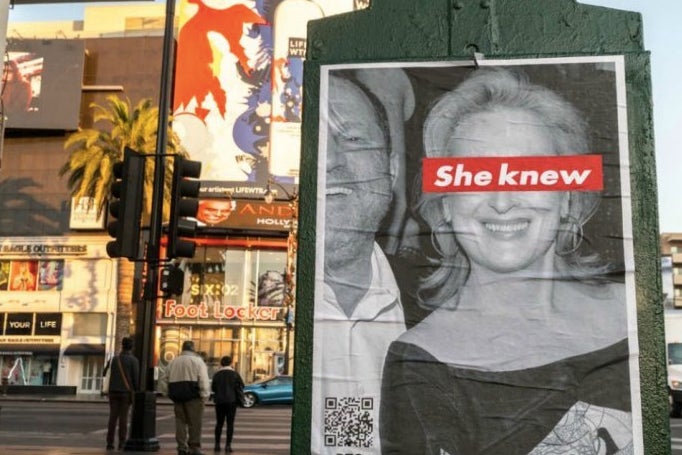 The poster shows a black and white photograph of a smiling Streep beside a laughing Weinstein, declare that “she knew” via a red-and-white strip over her eyes (a reference to the work of artist Barbara Kruger).